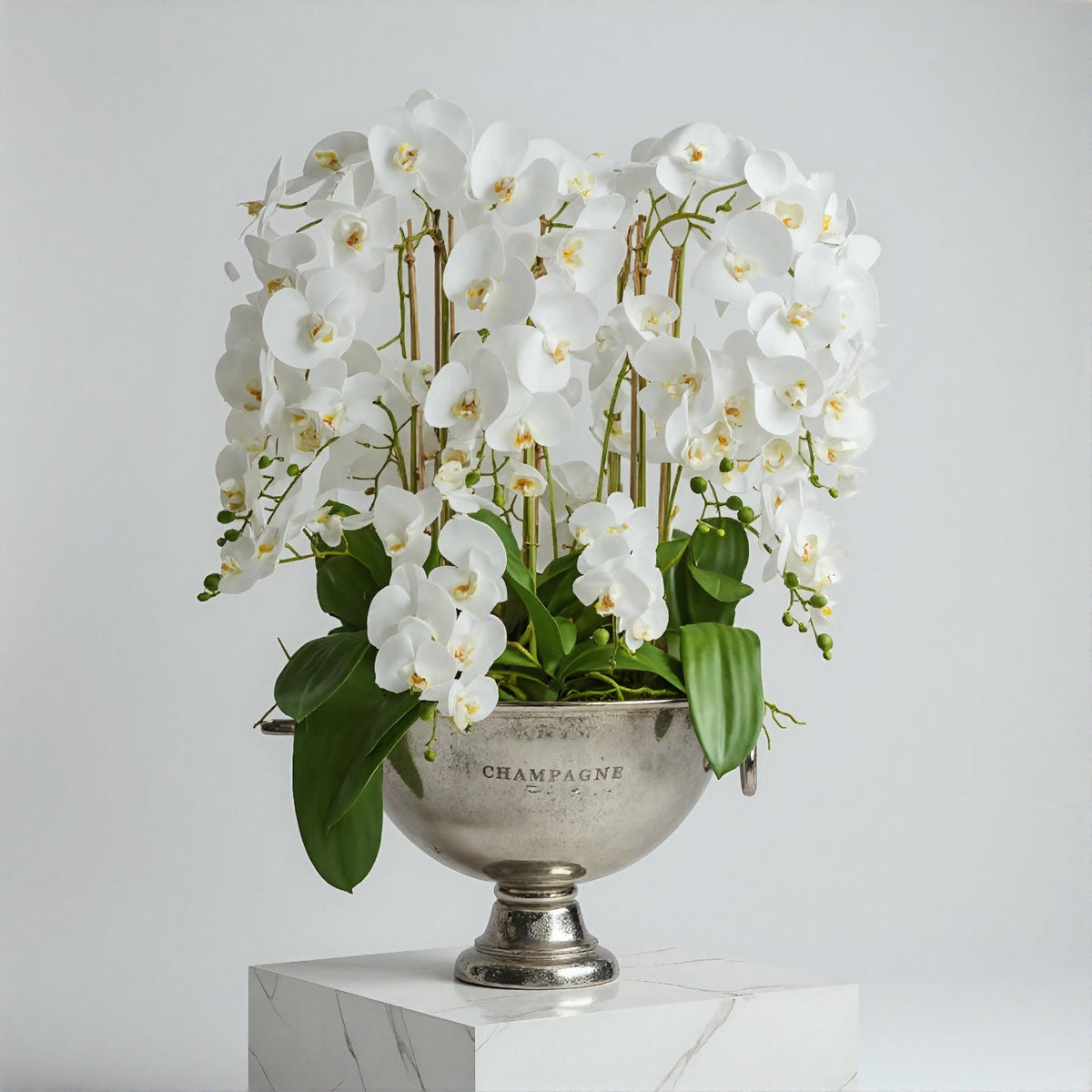 Luxury artificial white orchids in a silver champagne cooler for an office reception desk